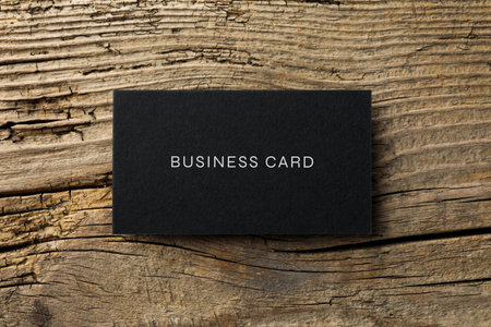 Black business card on wooden table, top viewの写真素材