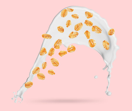 Rolled oats and milk splash on pink backgroundの写真素材
