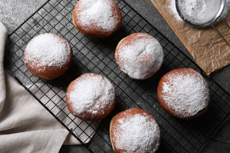 Delicious sweet buns, powdered sugar and strainer on table, flat layの写真素材