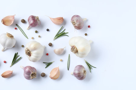 Fresh garlic, rosemary and peppercorns on white background, flat lay. Space for textの写真素材