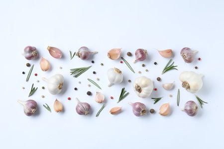 Fresh garlic, rosemary and peppercorns on white background, flat layの写真素材