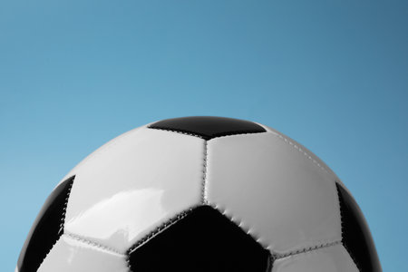 One soccer ball on light blue background, closeup. Sports equipment