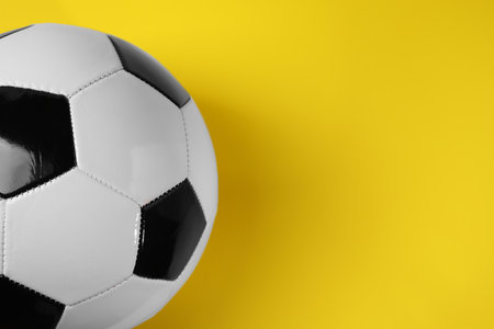One soccer ball on yellow background, above view with space for text. Sports equipmentの写真素材