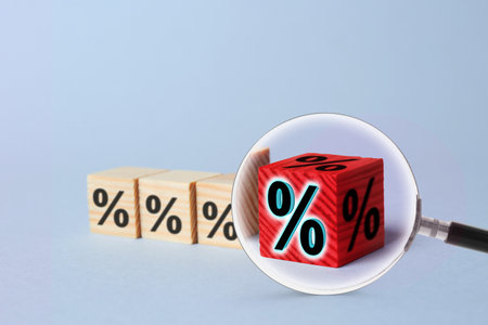 Best mortgage interest rate. Red cube with percent sign among wooden ones on light background, view...