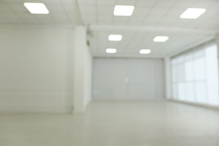 Empty room with white walls and laminated flooring, blurred viewの写真素材