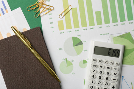 Accounting documents, magnifying glass, calculator and stationery on green background, flat lay