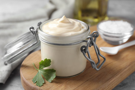 Tasty mayonnaise in jar and parsley on table, closeupの写真素材