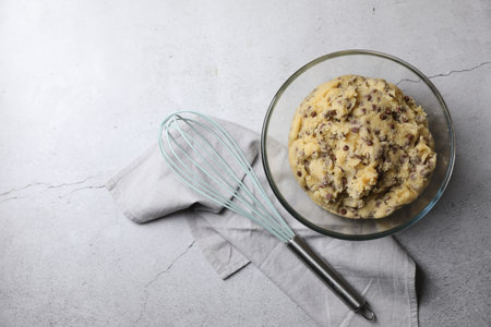 Chocolate chip cookie dough in bowl and whiskey on light gray table, flat lay. Space for textの写真素材