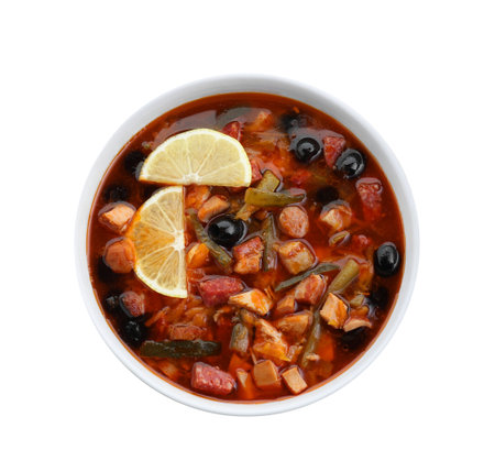 Meat solyanka soup with sausages, olives and vegetables in bowl isolated on white, top viewの写真素材
