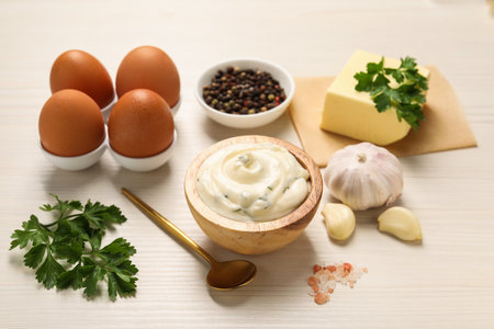 Tasty sauce with garlic and ingredients on white wooden tableの写真素材