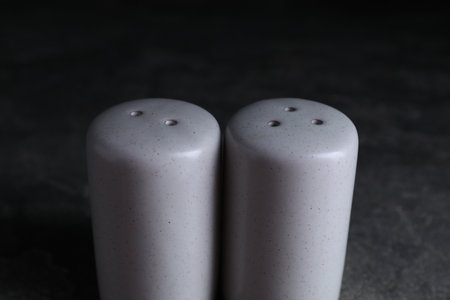Salt and pepper shakers on dark table, closeupの写真素材