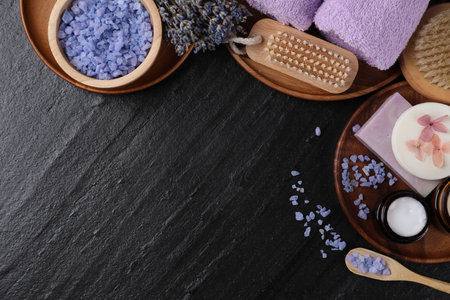 Flat lay composition with different spa products and lavender on black textured table. Space for textの写真素材