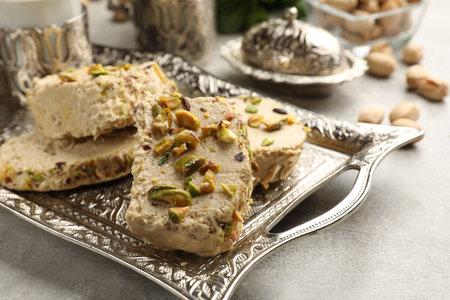Tasty pistachio halva on light gray table, closeup