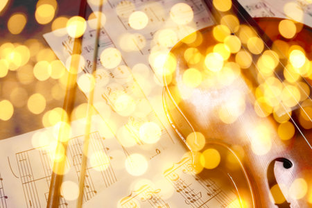 Christmas and New Year music. Violin and music sheets on wooden background, bokeh effectの写真素材