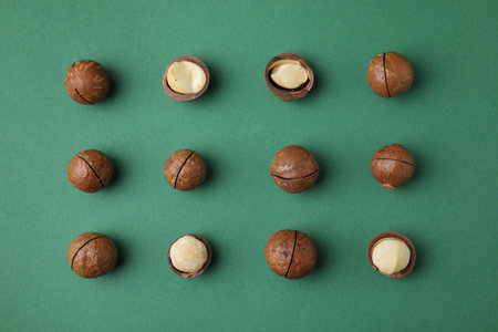 Tasty Macadamia nuts on green background, flat layの写真素材