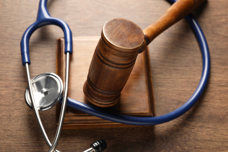 Law concept. Gavel and stethoscope on wooden table, closeupの写真素材