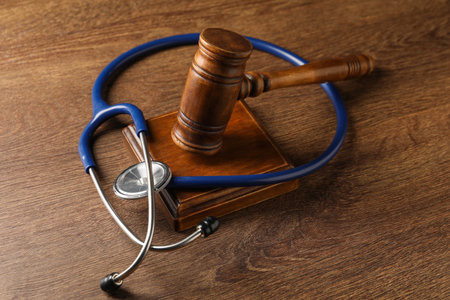 Law concept. Gavel and medical stethoscope on wooden tableの写真素材