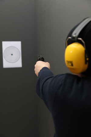 Man aiming at shooting target indoors, closeupの写真素材