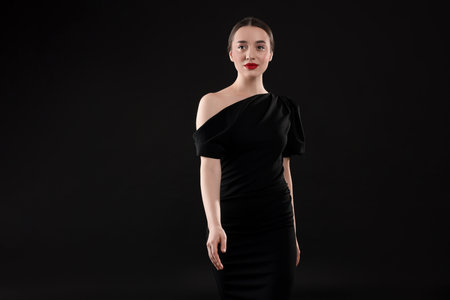 Beautiful young woman in elegant dress on black backgroundの写真素材