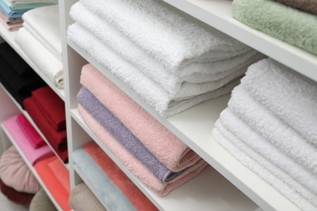 Bed linens and towels on shelves in shopの写真素材