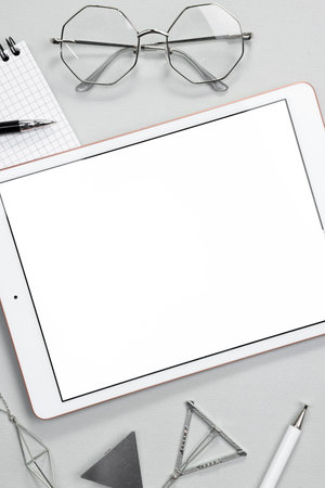 Flat lay composition with modern tablet on light gray background. Space for text