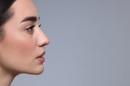 Portrait of beautiful young woman on gray background. Space for textの写真素材