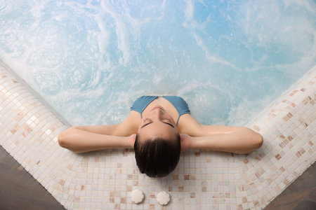 Beautiful woman relaxing in spa swimming pool, top viewの写真素材