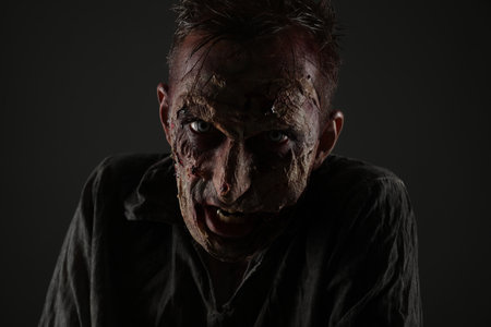 Scary zombie on dark background. Halloween monster