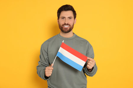 Man with flag of Netherlands on yellow backgroundの写真素材