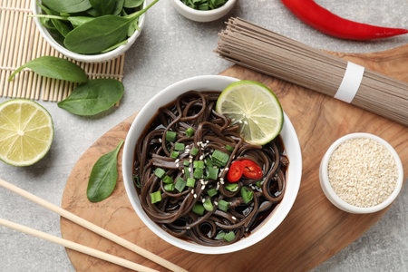 Tasty buckwheat noodles (soba) served on light gray table, flat layの写真素材