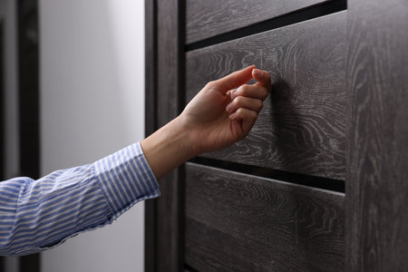 Woman knocking on door indoors, closeup viewの写真素材