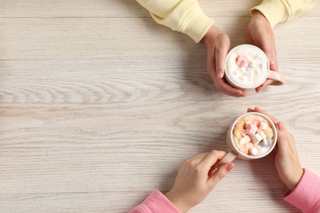 Women having coffee break at light wooden table, top view. Space for textの写真素材