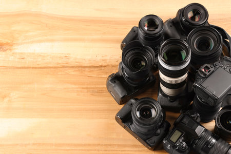 Modern cameras on wooden table, space for textの写真素材