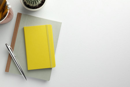 Flat lay composition with notebooks and pen on white table. Space for textの写真素材