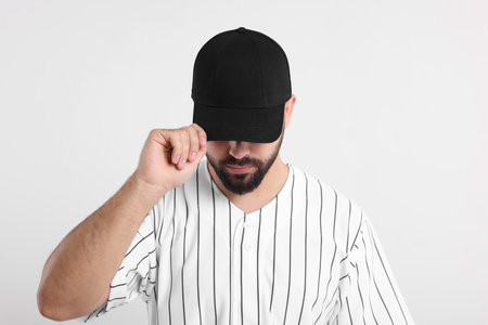 Man in stylish black baseball cap on white backgroundの写真素材