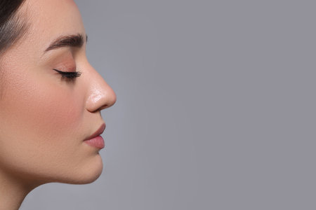 Portrait of beautiful young woman on gray background. Space for textの写真素材