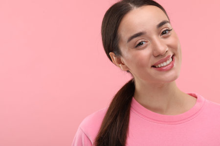 Beautiful woman with clean teeth smiling on pink background, space for textの写真素材
