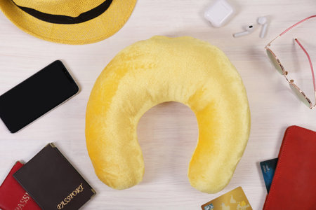 Flat lay composition with yellow travel pillow and smartphone on white wooden backgroundの写真素材