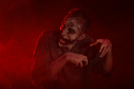 Scary zombie on dark background. Halloween monster