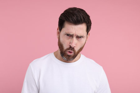 Portrait of surprised man on pink backgroundの写真素材