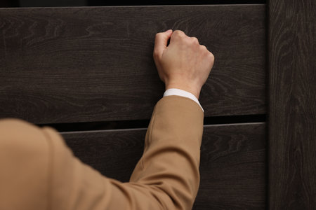 Collector knocking on door indoors, closeup viewの写真素材