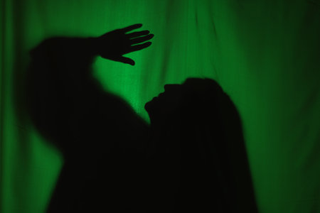 Silhouette of creepy ghost behind dark green clothの写真素材