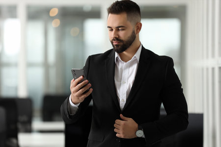 Handsome man with smartphone in office. Lawyer, businessman, accountant or managerの写真素材