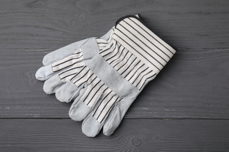Pair of color gardening gloves on gray wooden table, top view