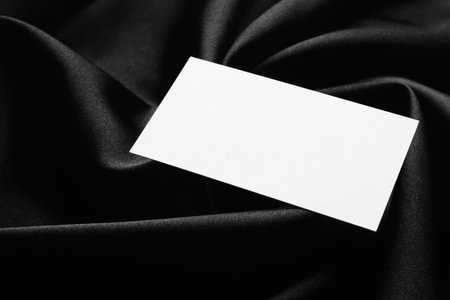 Blank business card on black fabric, closeup. Mockup for designの写真素材