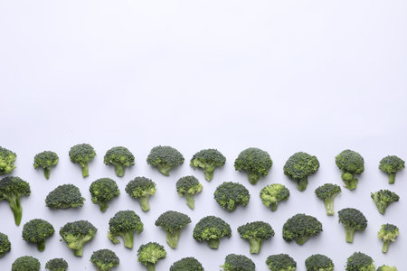 Many fresh green broccoli pieces on white background, flat lay. Space for textの写真素材