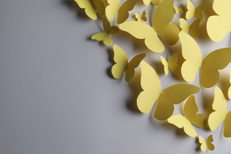 Yellow paper butterflies on light gray background, top view. Space for textの写真素材