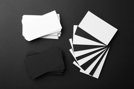 Blank business cards on black background, flat lay. Mockup for designの写真素材