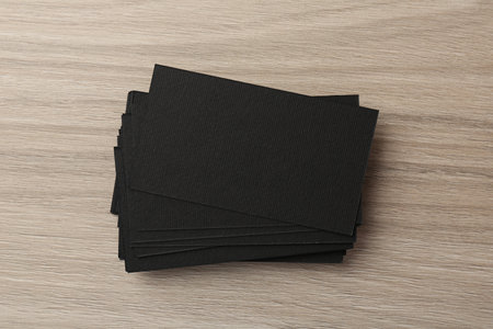 Blank black business cards on wooden table, top view. Mockup for designの写真素材
