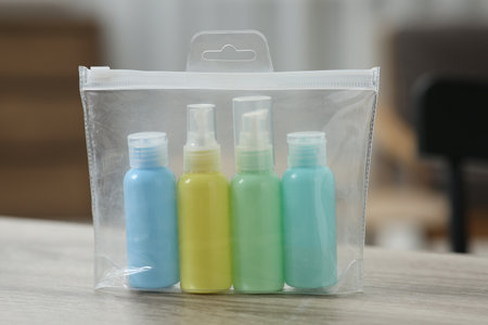 Cosmetic travel kit in plastic bag on wooden table, closeup. Bath accessoriesの写真素材